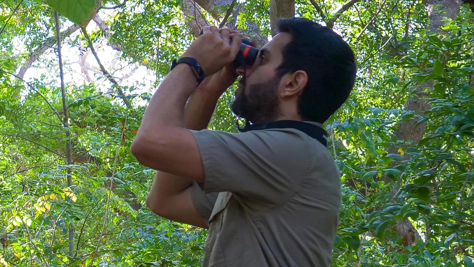 Man in nature watching wildlife through binofulars
