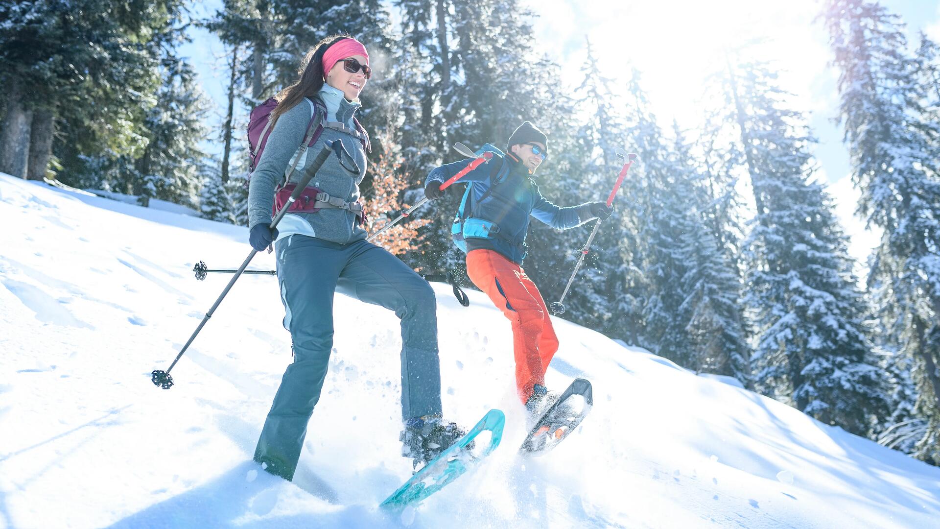 Couple dans une descente de montagne en raquette à neige