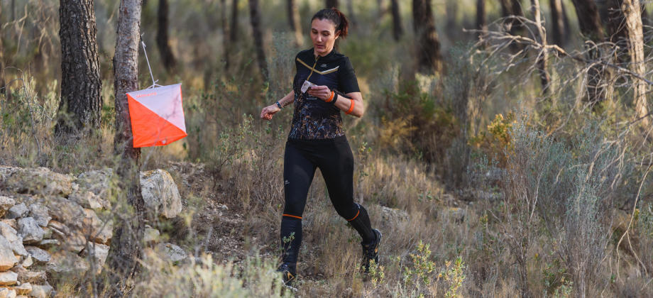 Orienteering woman punchs control Orienteering woman punchs control