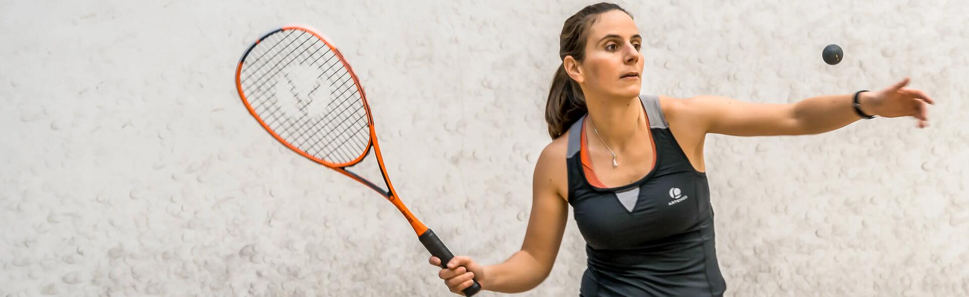 Women about to hit a squash ball with a racket