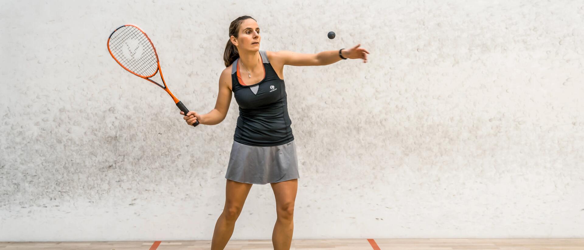 kobieta w stroju do gry w squasha z rakietką do squasha w dłoni