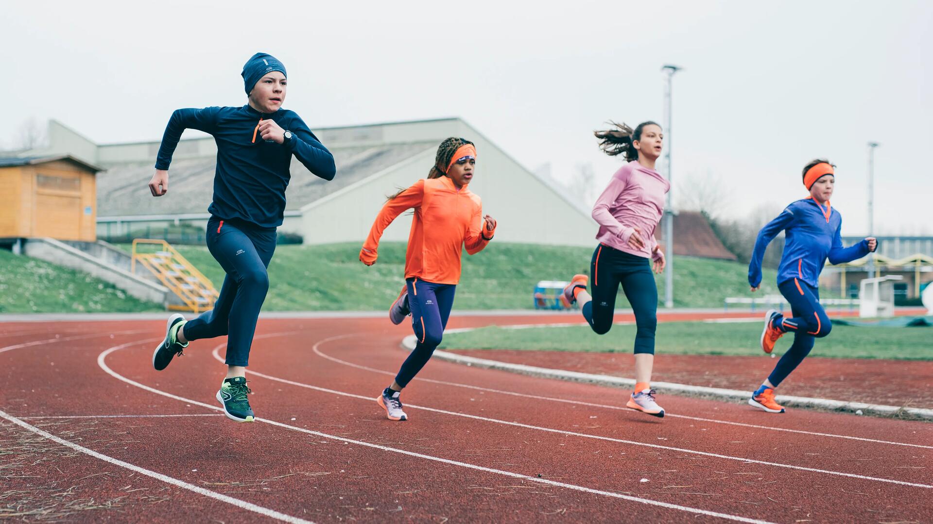 Des enfants qui courent sur une piste d'athlétisme 