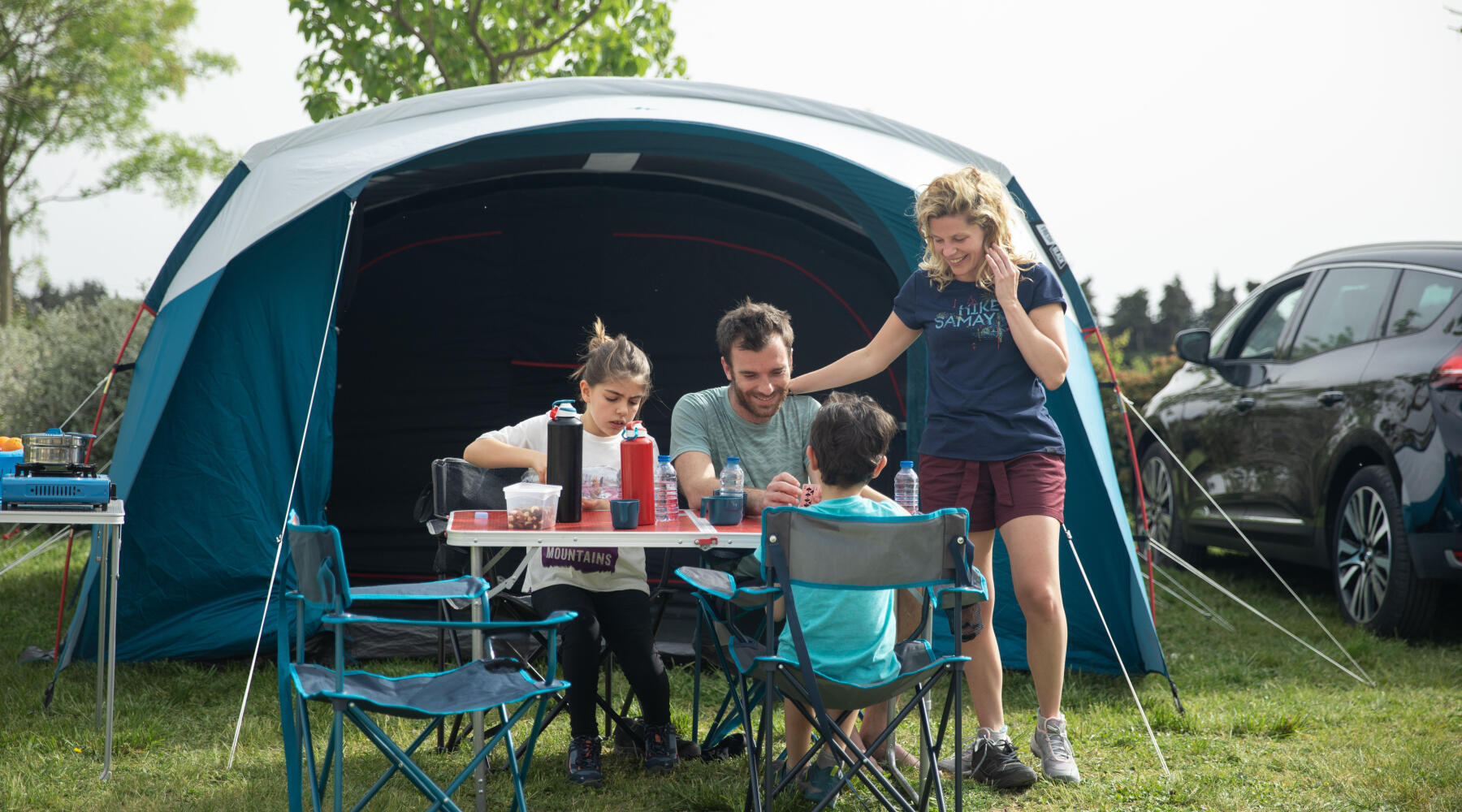 Família a fazer uma refeição numa tenda