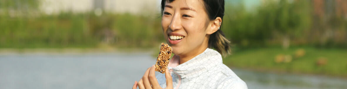 woman eating a granola bar while hiking
