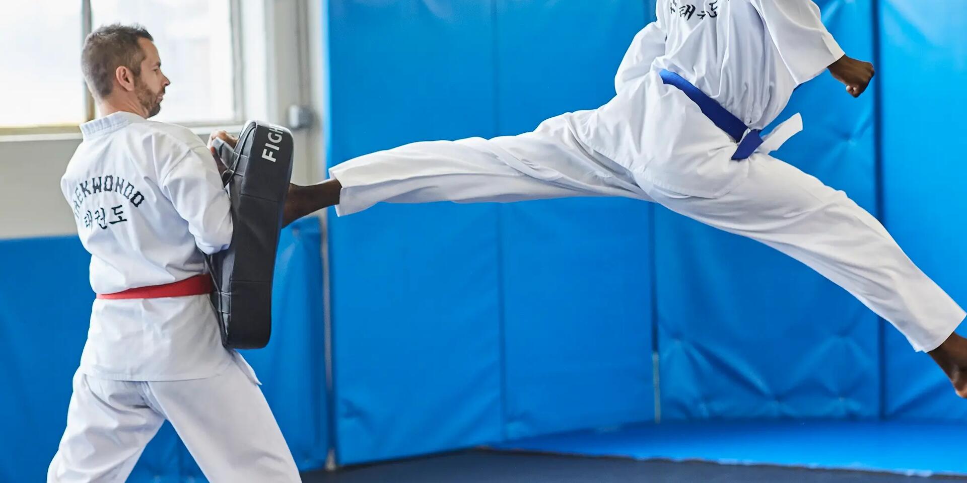 mężczyzna trenujący kopnięcia taekwondo  z trenerem