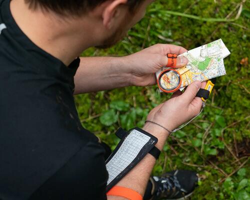 Mystery Cache im Wald, Geocacher mit Karte und Kompass