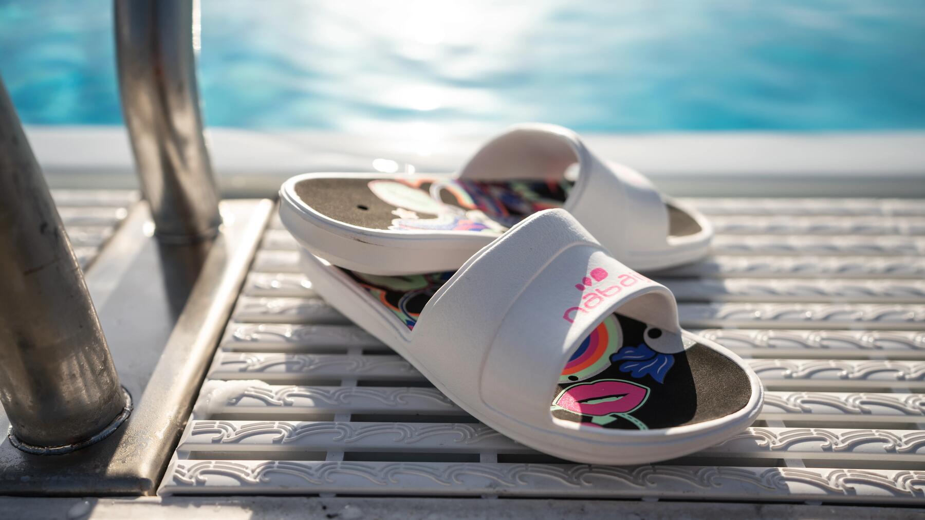 Weiße Wasserschuhe stehen am Pool