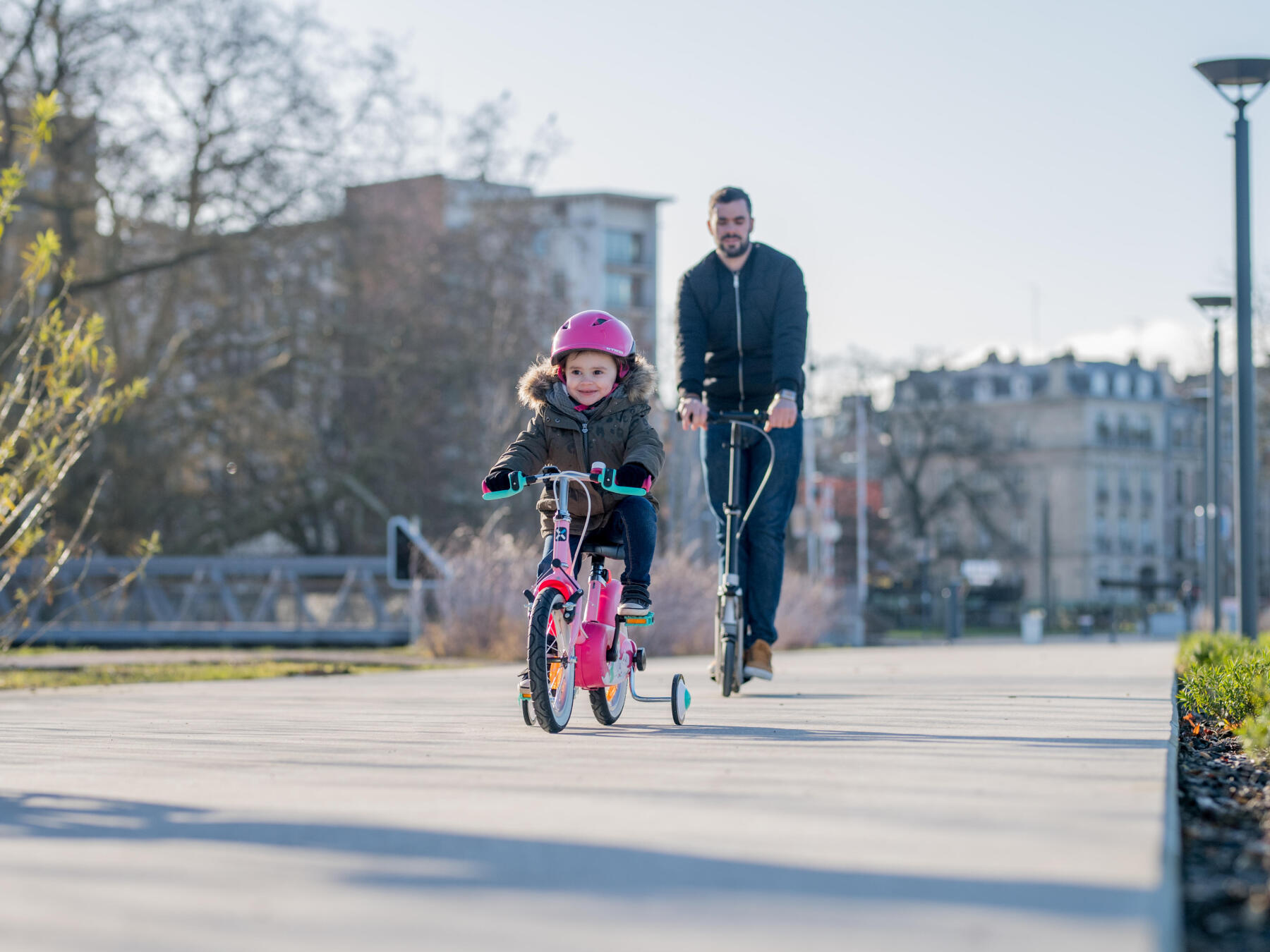 Un niño de 2 años aprende a andar en bicicleta de equilibrio en la  carretera de la aldea.