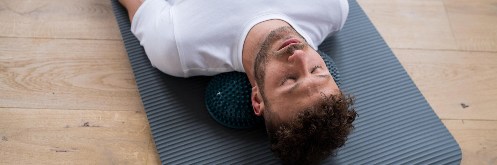 homme sur un tapis de yoga, les yeux fermés