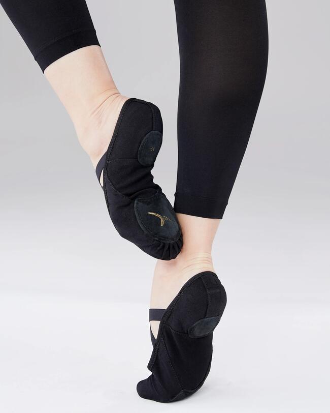Eine Person trägt schwarze Ballettschuhe.