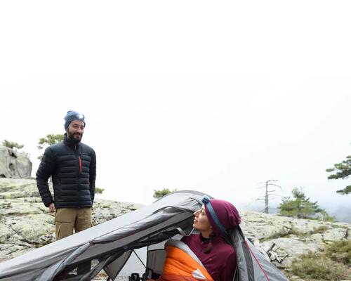 A woman in a sleeping bag inside her trekking tent
