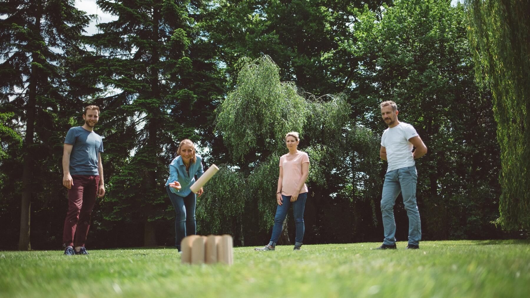 Een groep vrienden die molkky speelt in een tuin of park