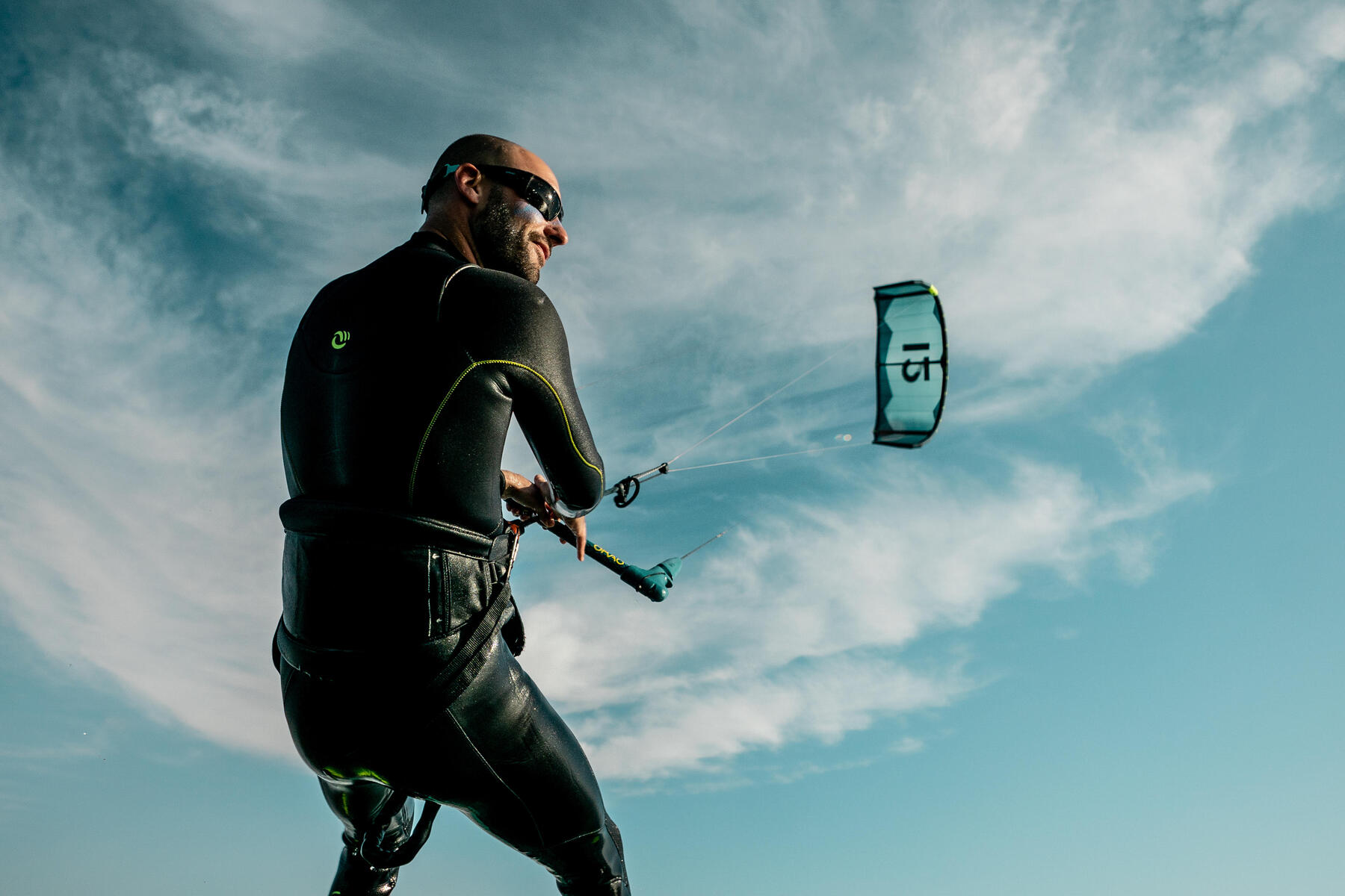 Mężczyzna pływający na kitesurfingu w okularach przeciwsłonecznych