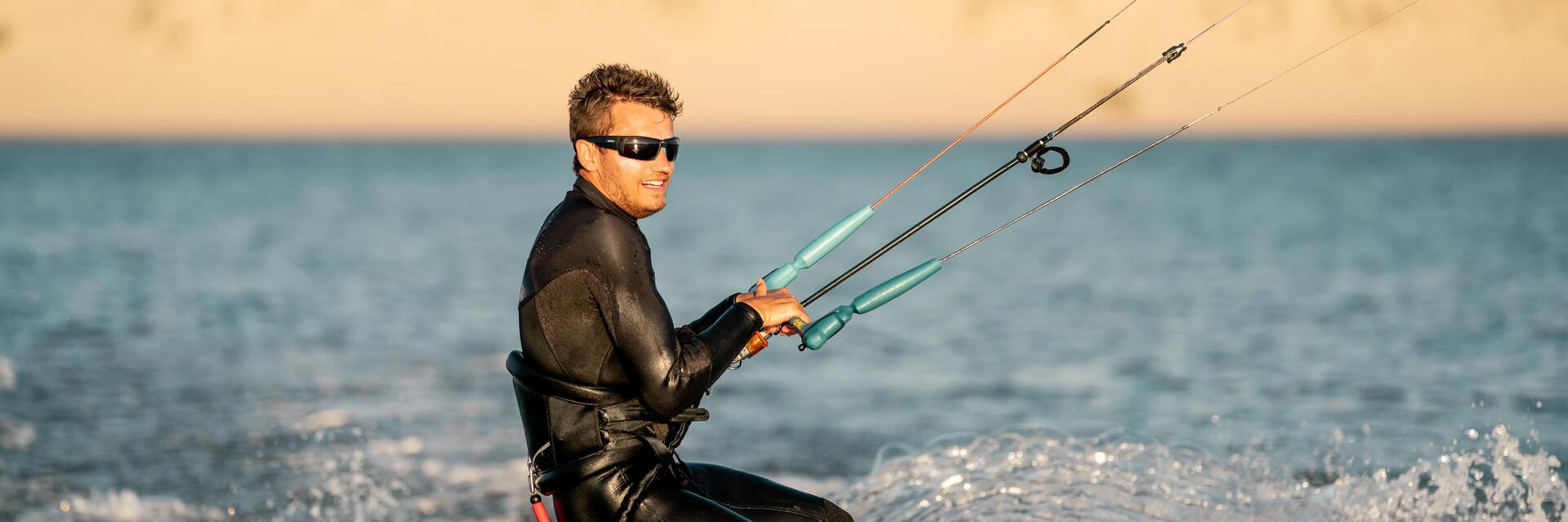 Mężczyzna pływający na kitesurfingu przygotowujący się do skoku