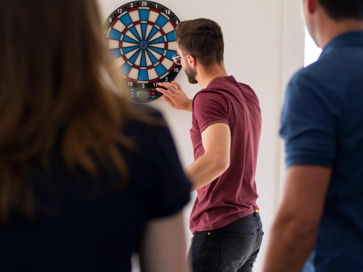Friends who play darts for concentration and fun