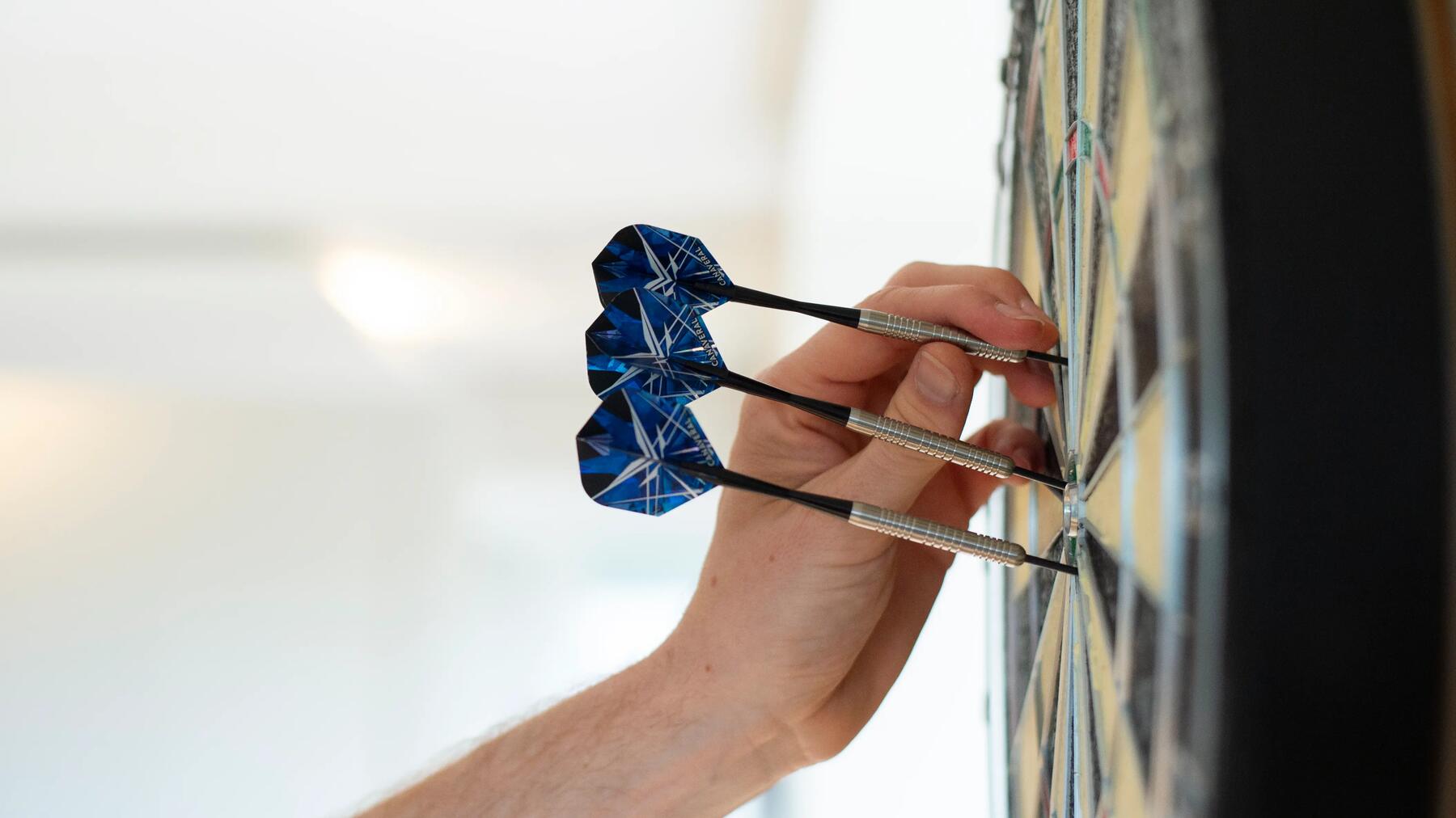 Man die zijn matchdart uit het dartbord haalt