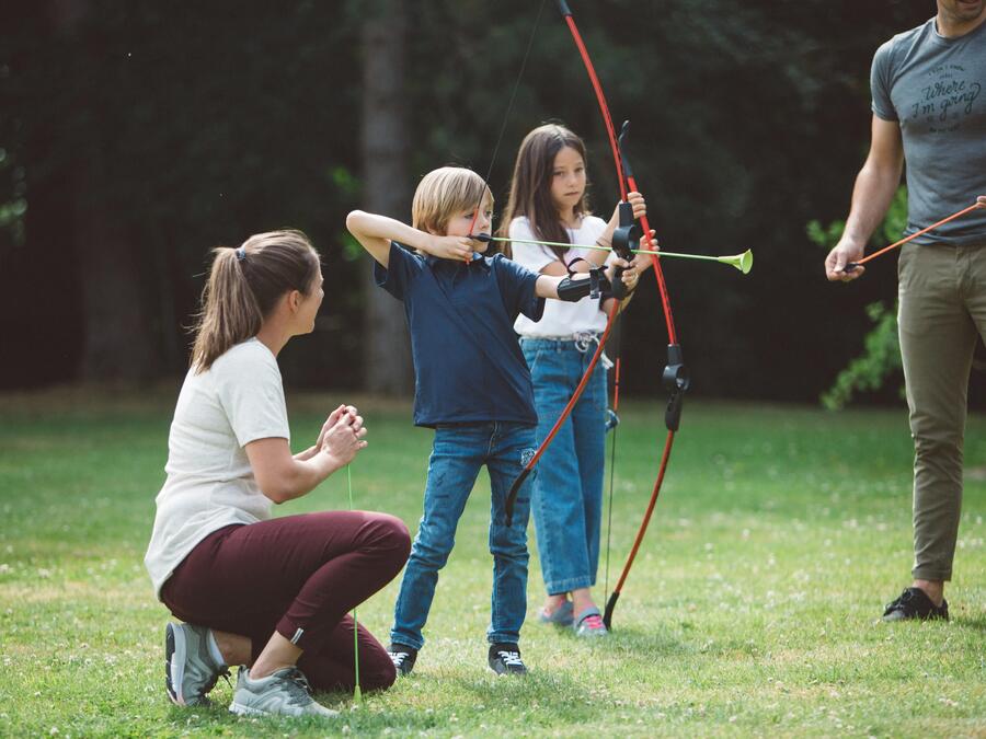 Child holding bow and arrow, ready to shoot