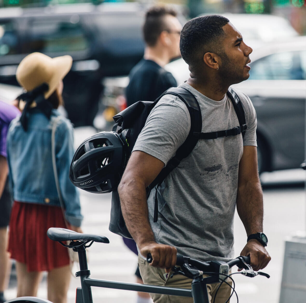 man walking downtown next to his bike