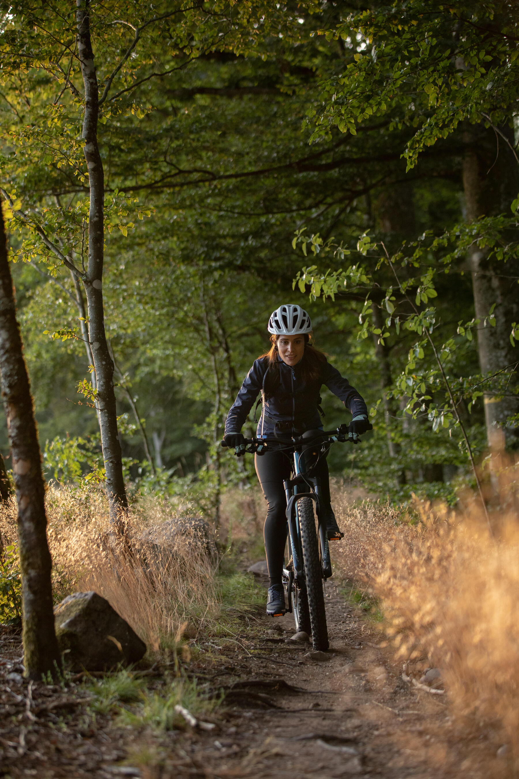 Kobieta jadąca na rowerze elektrycznym po lesie