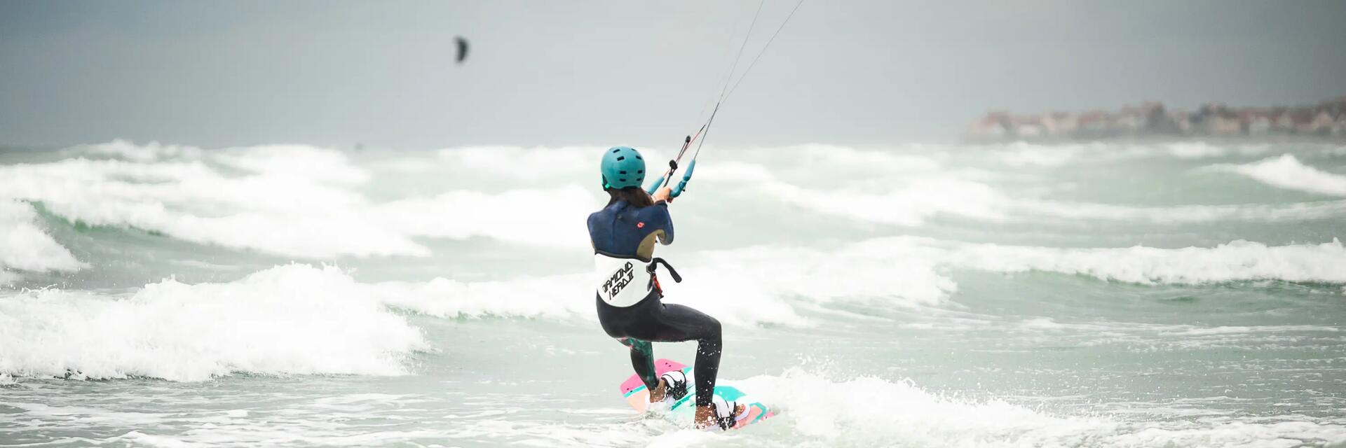 Rückenansicht einer Frau beim Kitesurfen auf dem offenen Meer