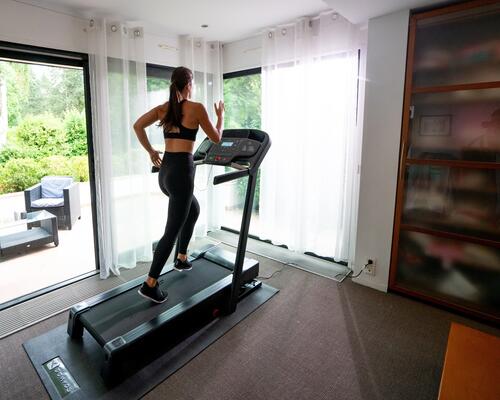 Mulher a correr na passadeira de corrida domyos t540c