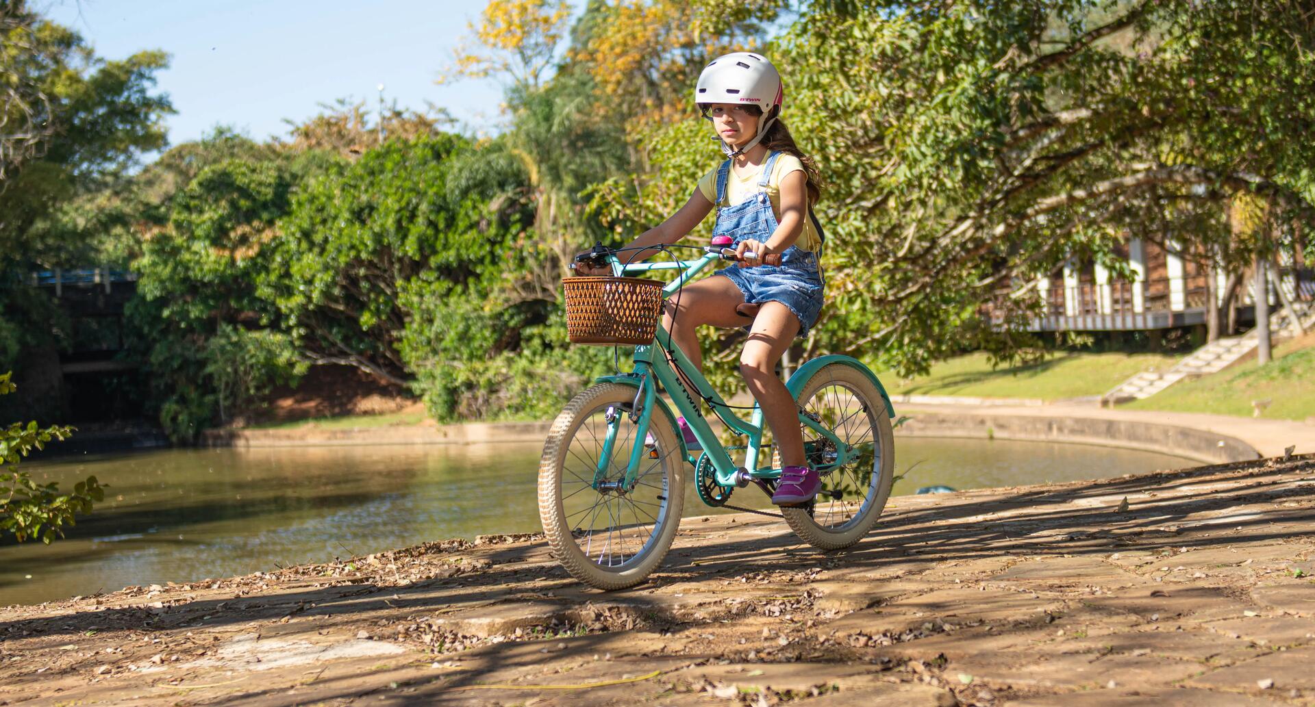 dziewczynka jadąca na rowerze miejskim w kasku