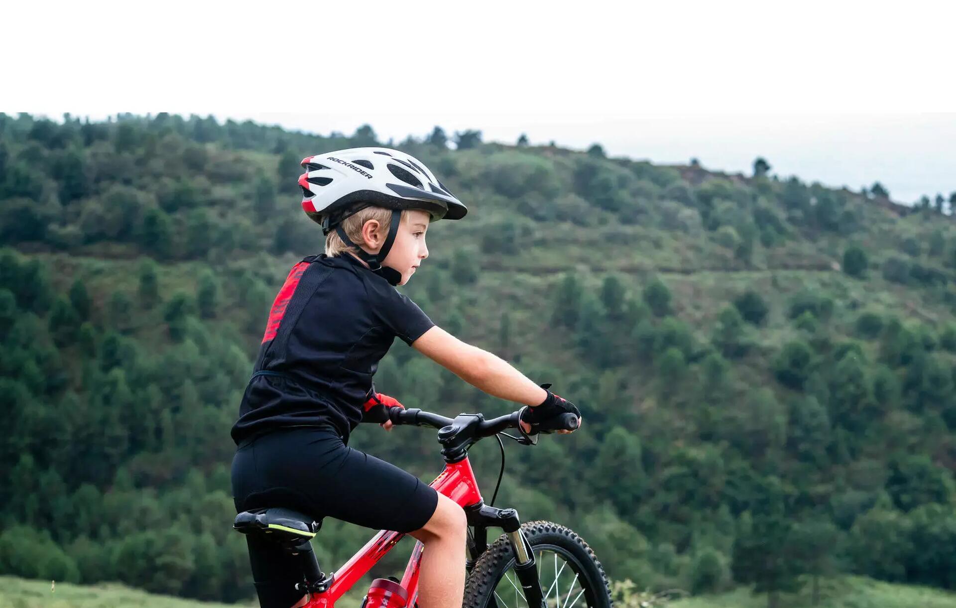 chłopiec na rowerze MTB w kasku i stroju rowerowym