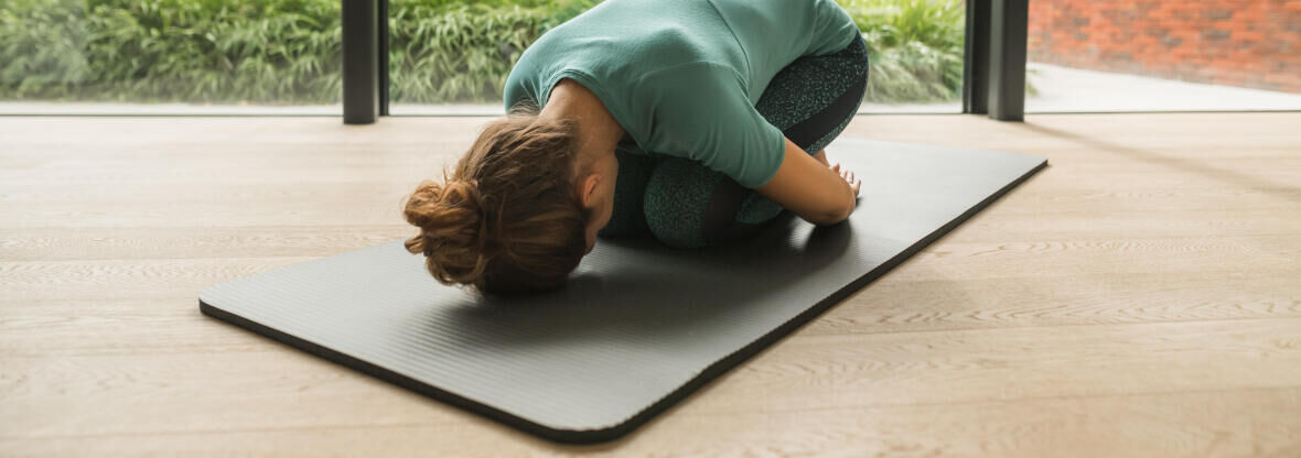 woman doing Pilates at home on her mat