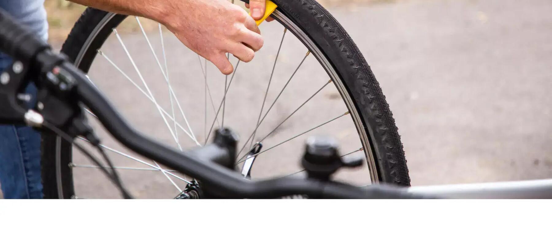 Mann setzt Reifenheber an Fahrradmantel an