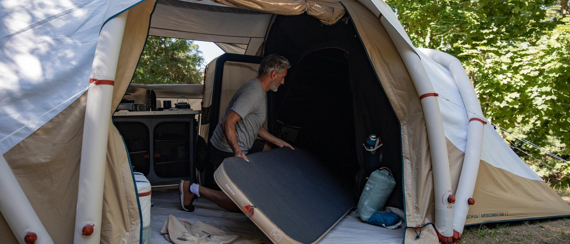 Mann mit Luftmatratze in Zelt 