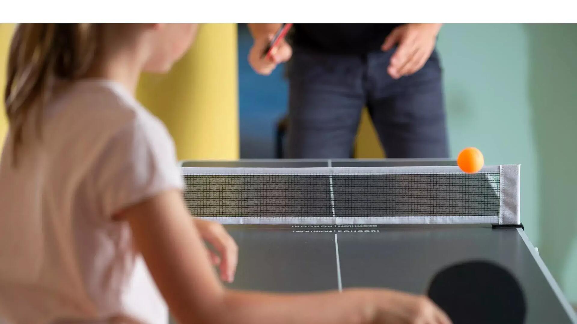 Petite fille qui joue au ping pong avec son papa