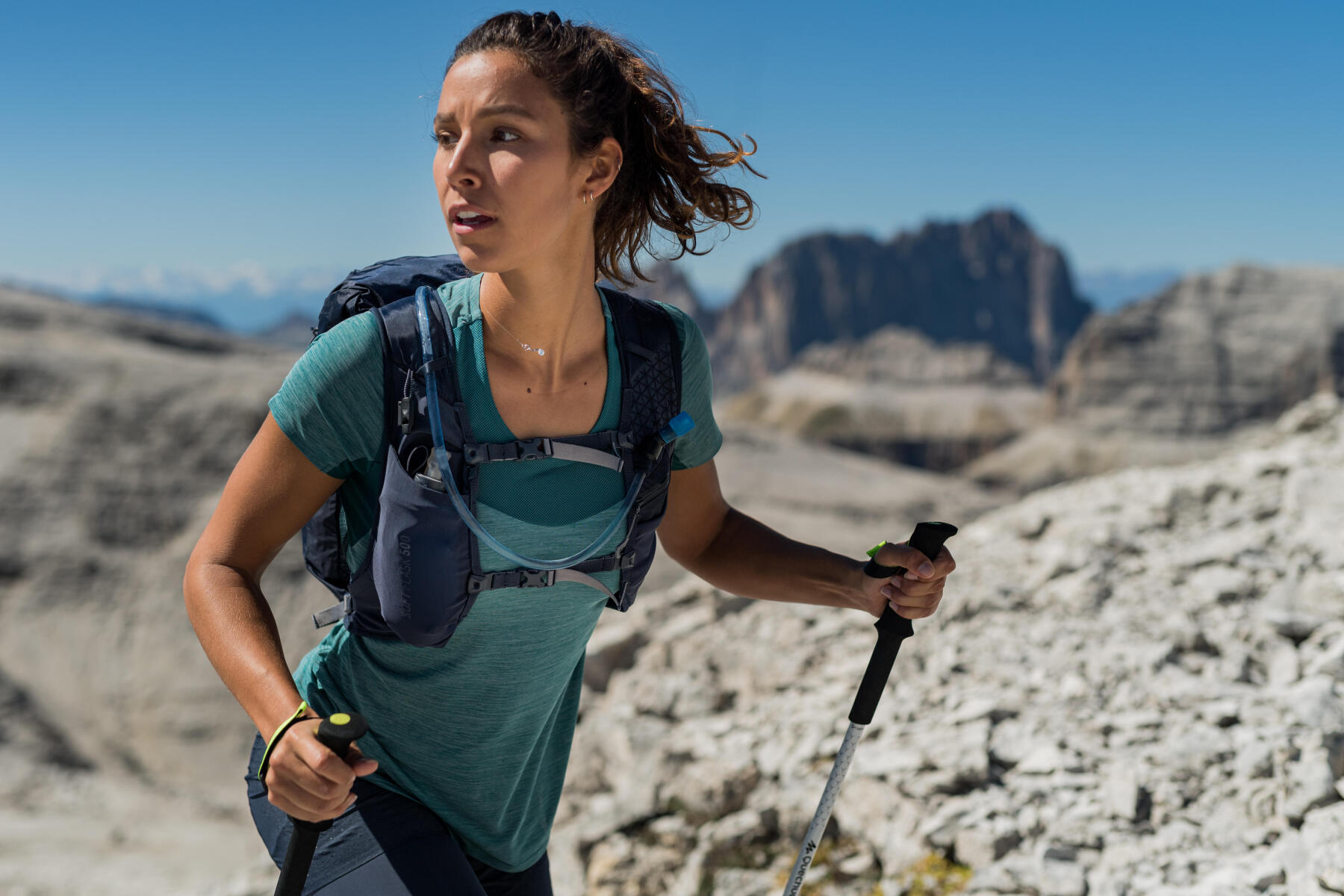 Sporty Woman Hiker with Backpack and Trekking Sticks Hiking in the