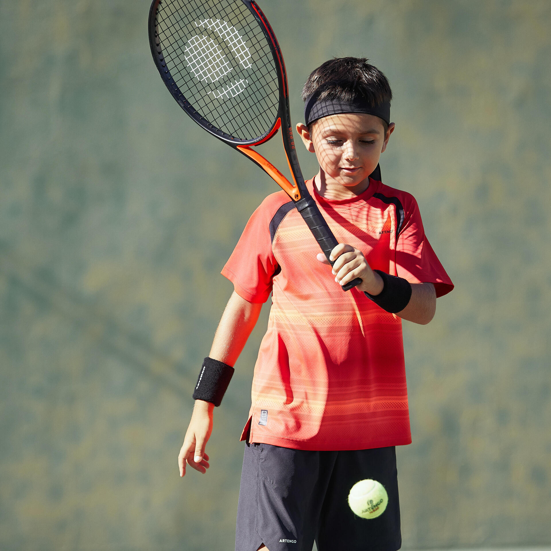 little boy with his tennis racket on the court