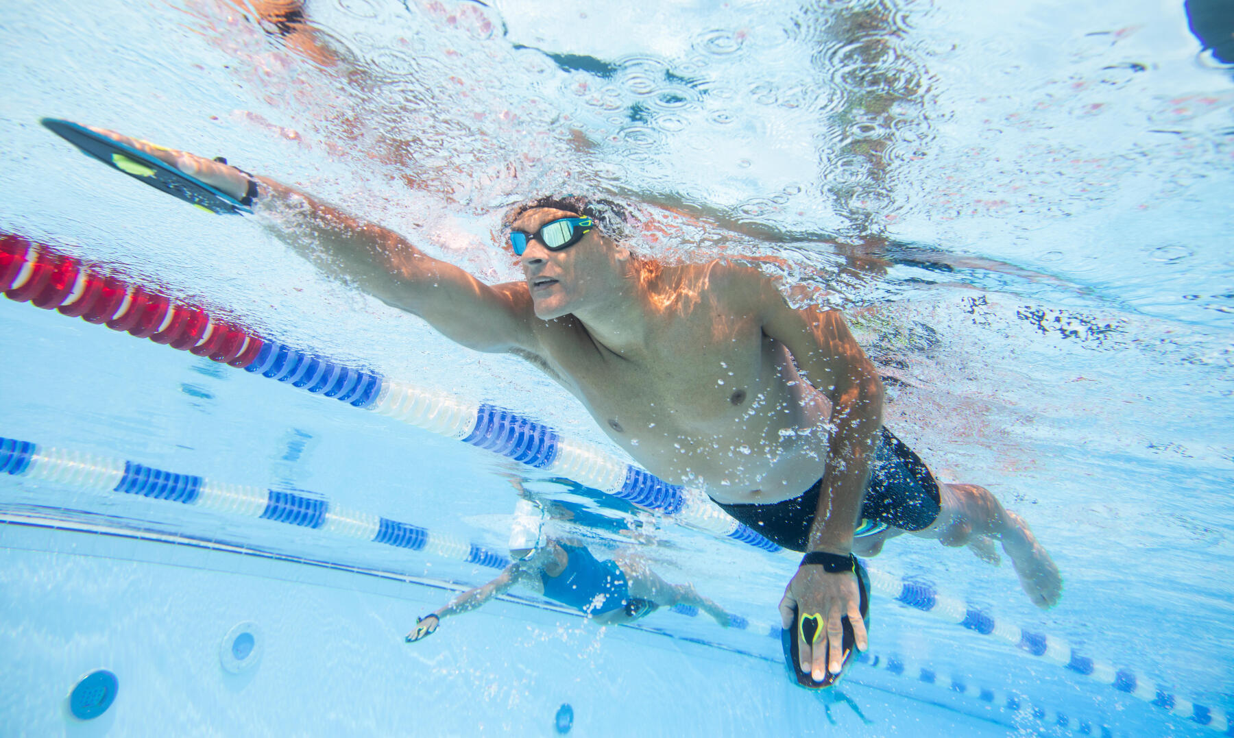 Nageur qui utilise des plaquettes de natation comme accessoire d'entrainement