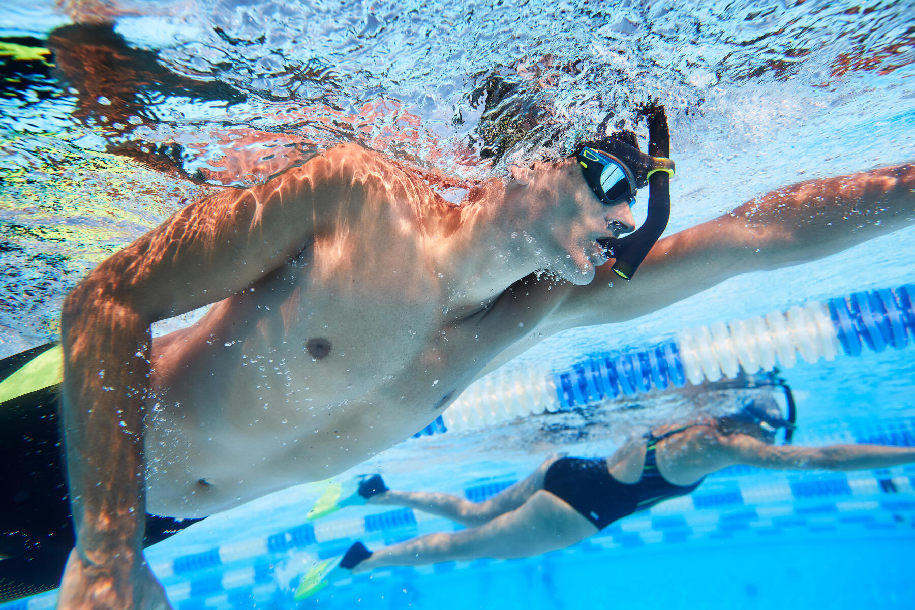 Une nageuse et un nageur vus sous l'eau qui s'entrainent avec un tuba frontal