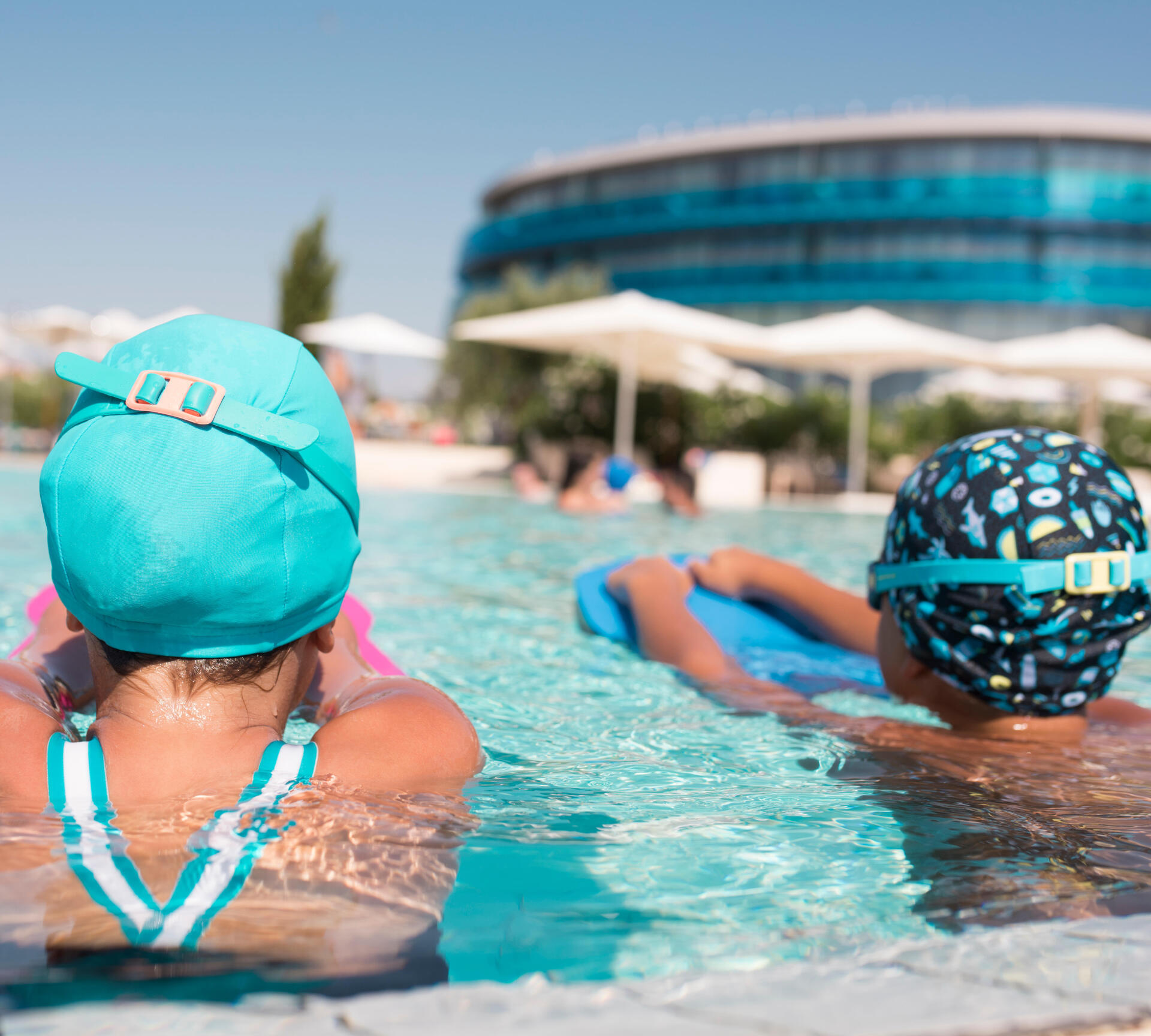 crianças com toucas na piscina