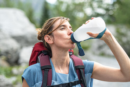woman drinking water on a hike