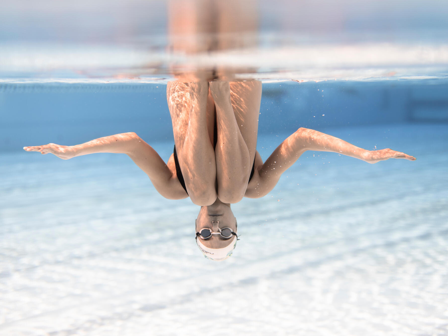 Lalie Chassaigne faisant un groupé bascule vu de face sous l'eau