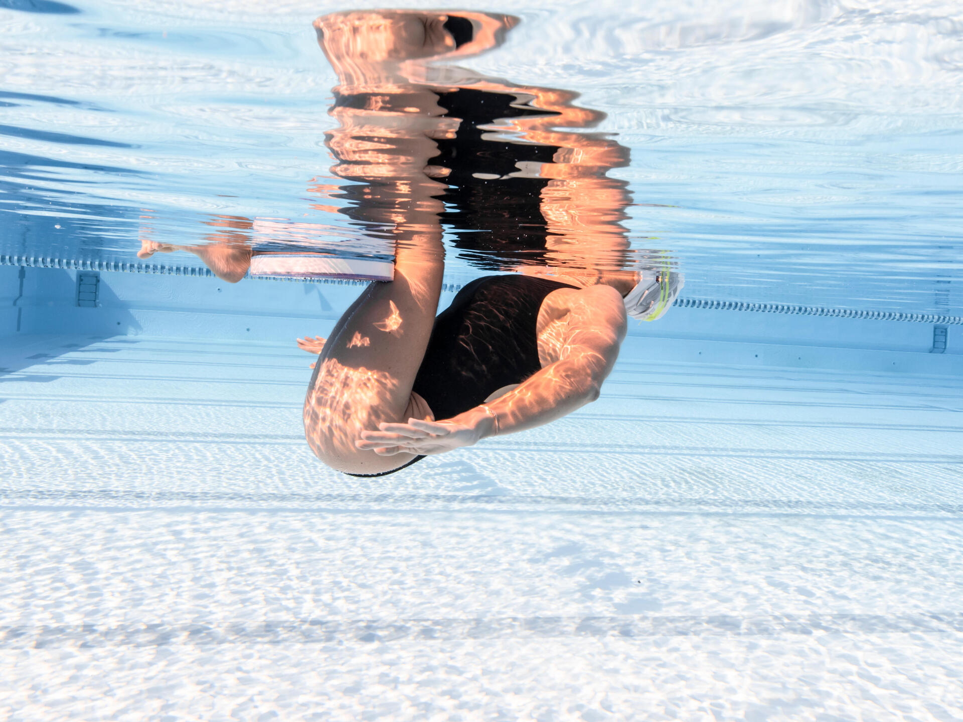Etape 2 du groupé bascule en natation synchronisée : genoux ramenés près de la poitrine