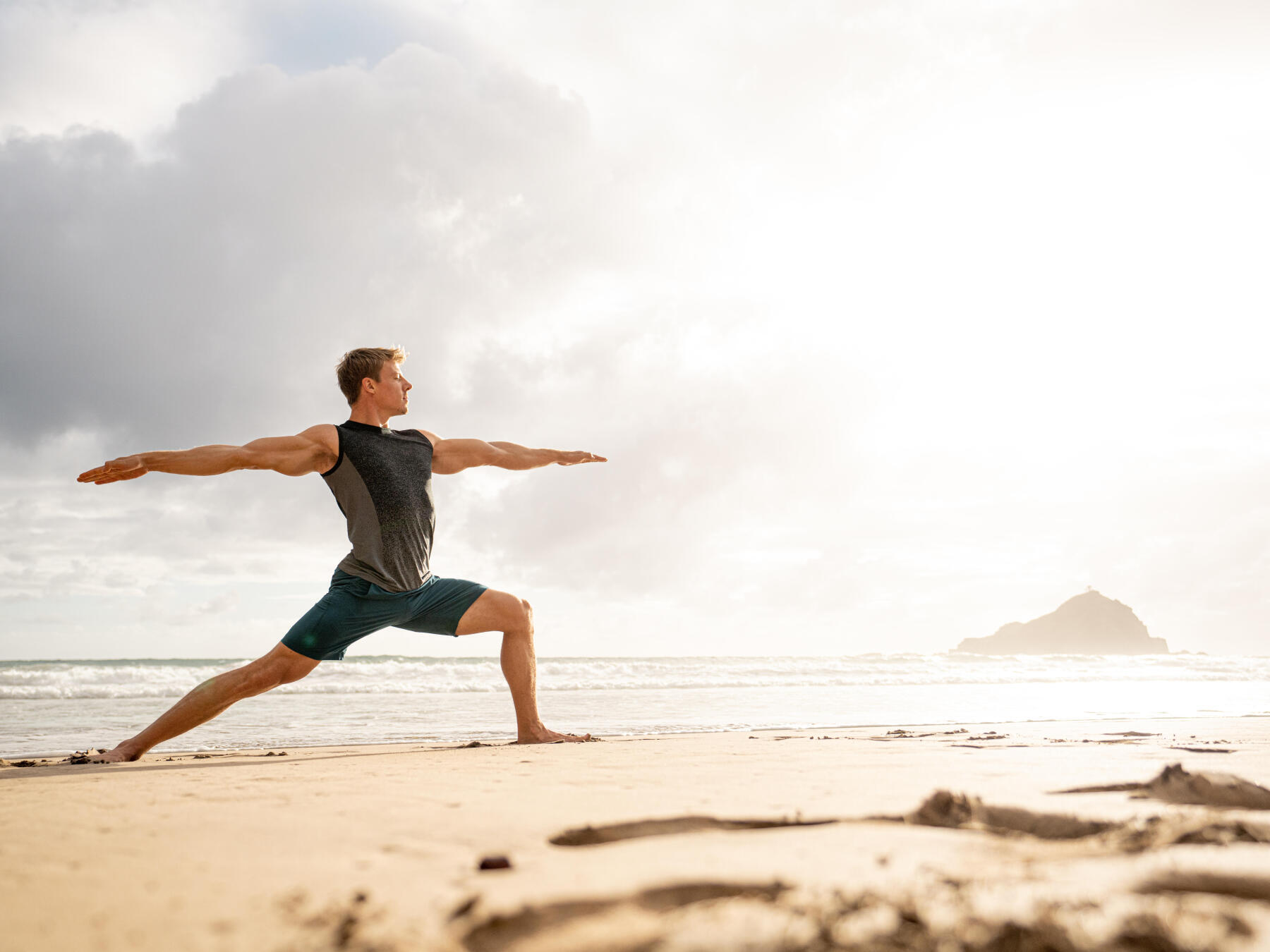 man doing yoga in front of the sea