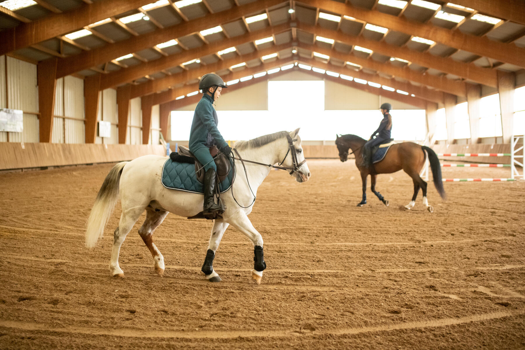 Deux cavaliers en début de leçon d'équitation en train de faire une détente