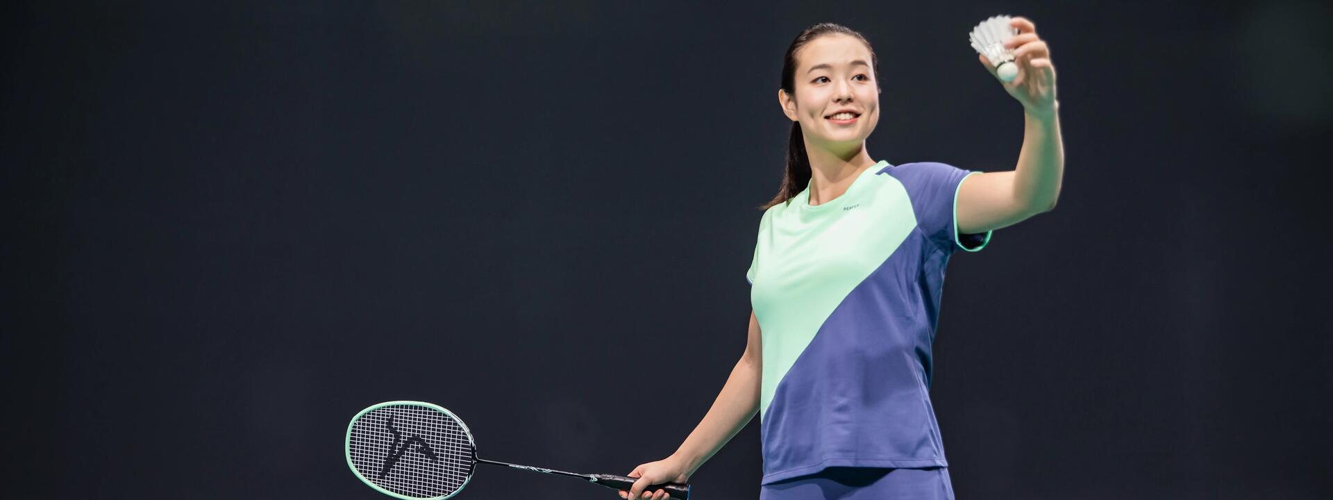 Kobieta w stroju badmintonowym trzymająca rakietkę i lotkę do gry w badmintona