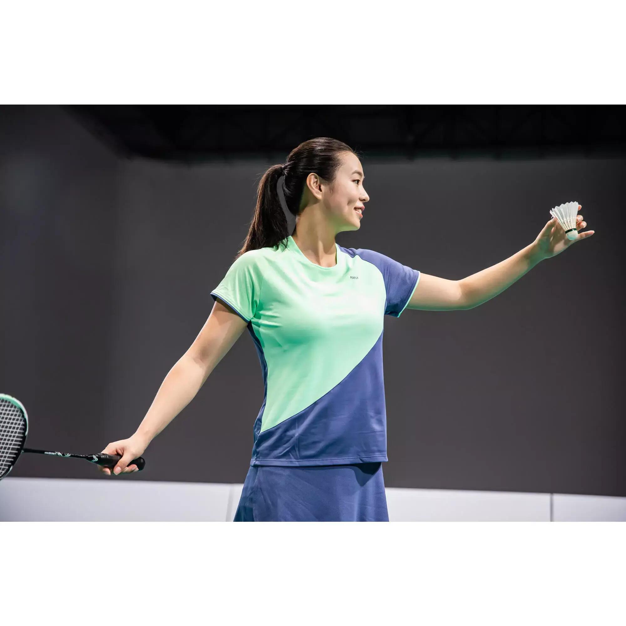 kobieta w odzieży do badmintona trzymająca lotkę i rakietę badmintonową