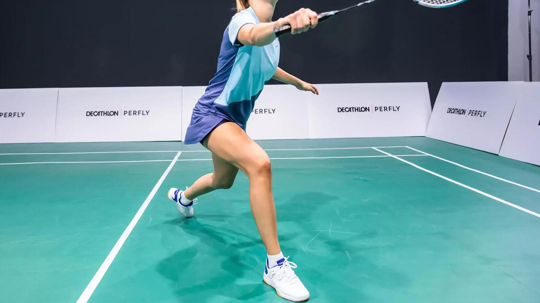 kobieta w butach do badmintona odbijająca lotkę rakietą badmintonową