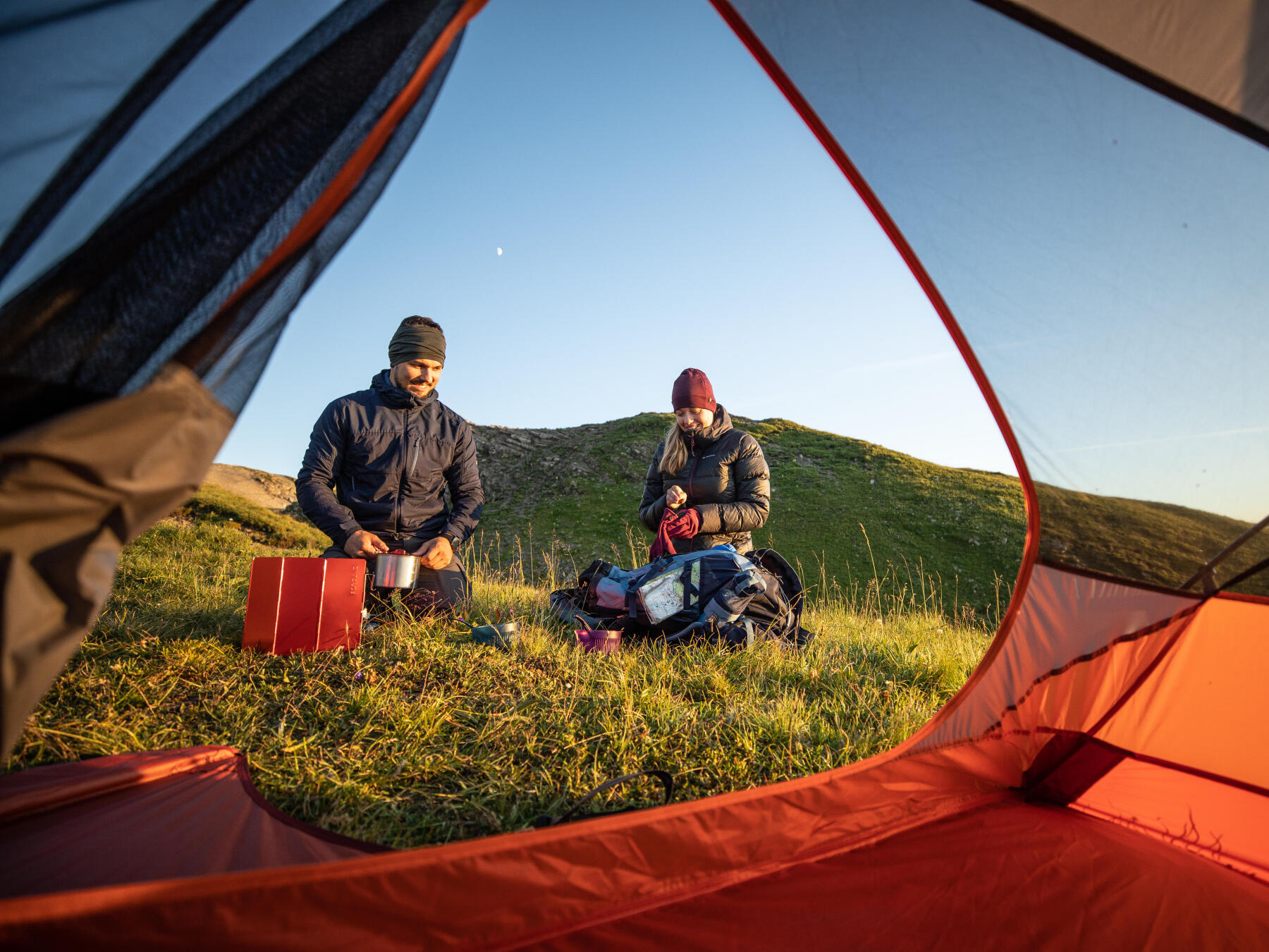 homem e mulher a cozinhar num acampamento em bivaque