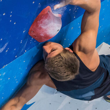 A man scaling an indoor climbing wall