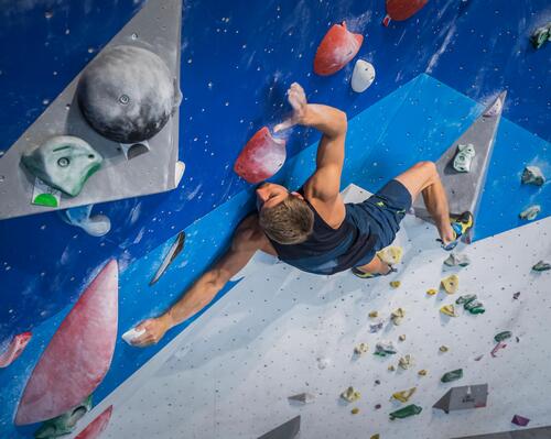 A man scaling an indoor climbing wall