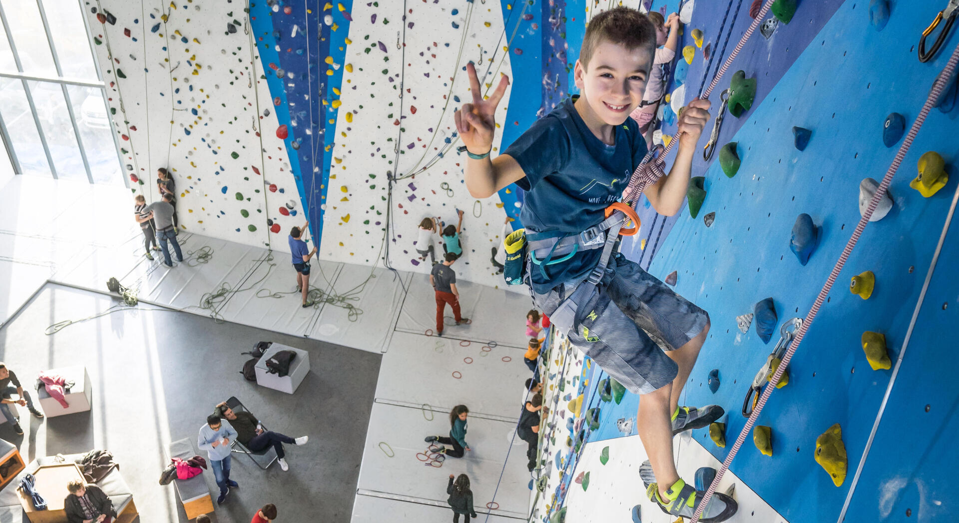 Smiling little boy climbing and doing a peace sign