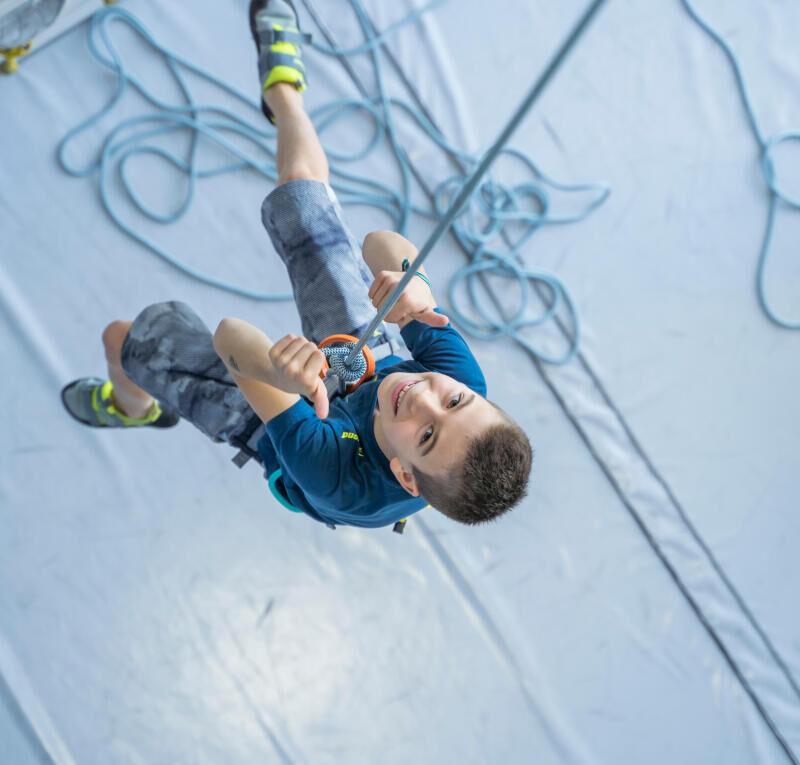 little boy climbing with thumbs up