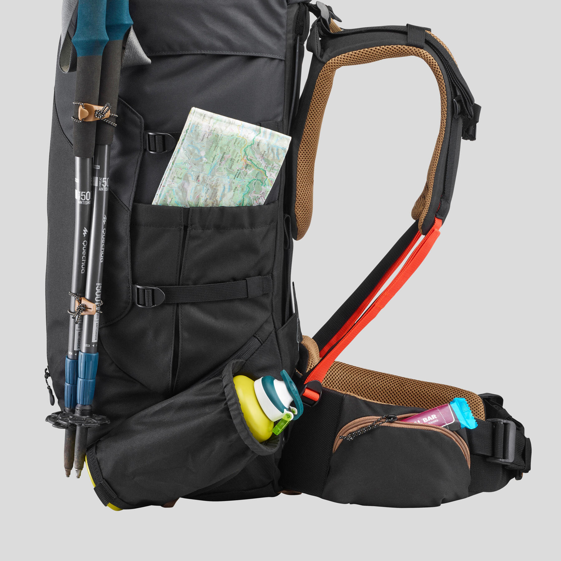 Rucksack seitlich fotografiert und mit Laufstöcken, Trinkflasche und Karte ausgerüstet.